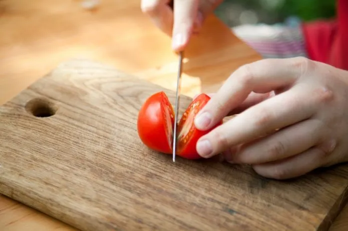 Разрезают томат