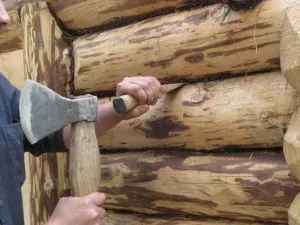 Фото: процесс конопатки деревянного дома джутом