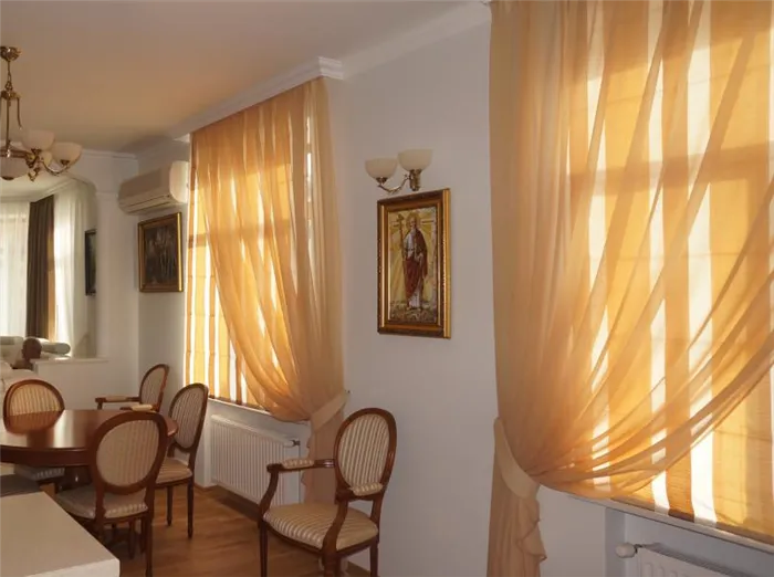 Светло-коричневый тюль на окнах классической гостиной